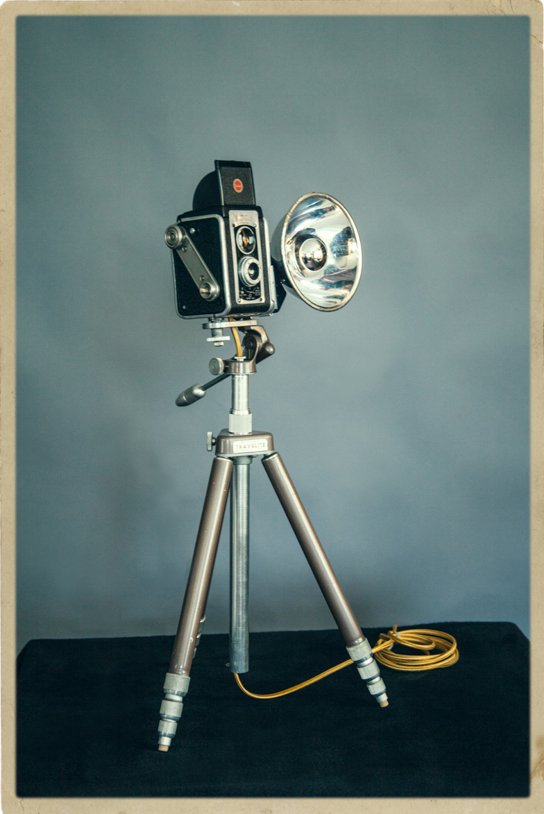 Product photo of a lamp made out of a repurposed antique camera and tripod.