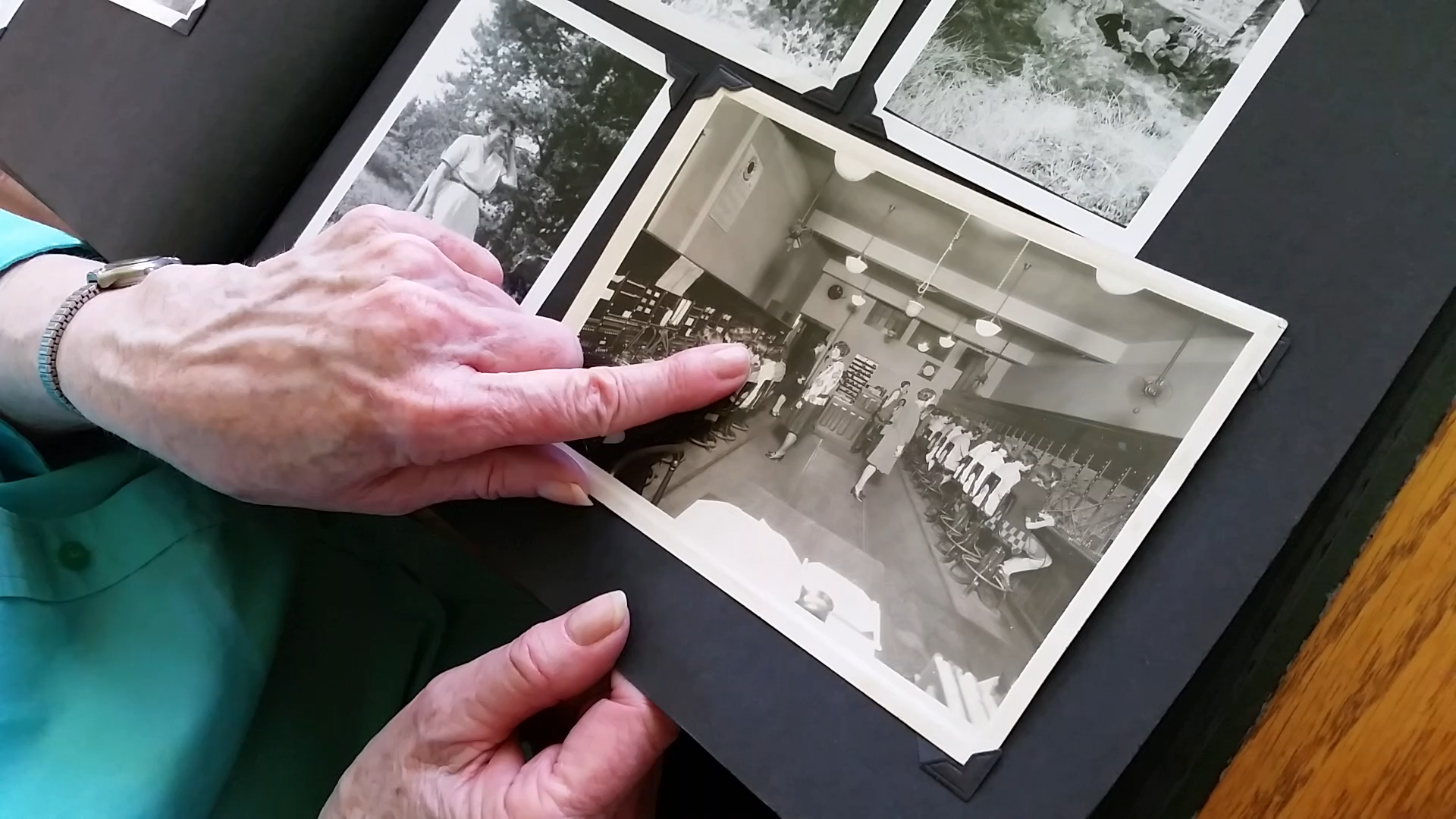 Negatives of various sizes on a light table, and one held by a hand in a white cotton glove.